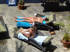 two hot girls poolside in waikiki taking their tops off