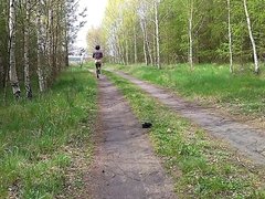 Crossdresser in sexy outfit & walking in forest near a road