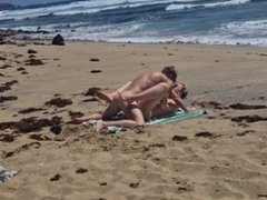 Fille qui bronze seins nus se fait baiser à la plage sur le sable, Naemyia