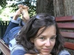 Beautiful girl shows here gorgeous bare feet in the park
