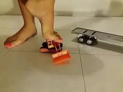 Girl crushing toy truck barefoot