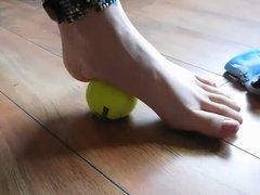 Hannah rolling a tennis ball with her long toes