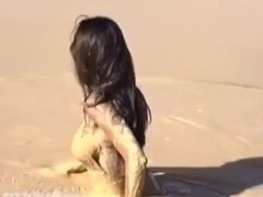 Girl in latex catsuit takes a bath in the mud