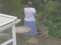 Watering in a blue and white skirt and half stripped