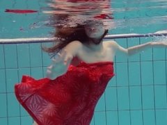 Red Dressed teen swimming with her eyes opened