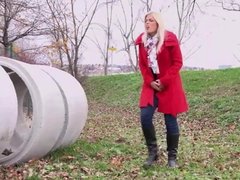 Blonde pisses on field behind concrete rings 25641