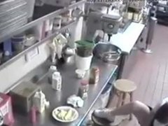 EMPLOYEE PUTS A SPECIAL  SAUCE  ON A HOT  DOG