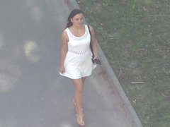 Sexy girl in a short dress walking down the street