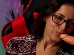 Woman with glasses sucking dildo sensually