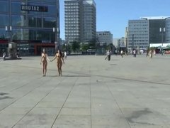 Two girls walk naked on a city street