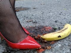 wife crush bananas and tomatos in red heels